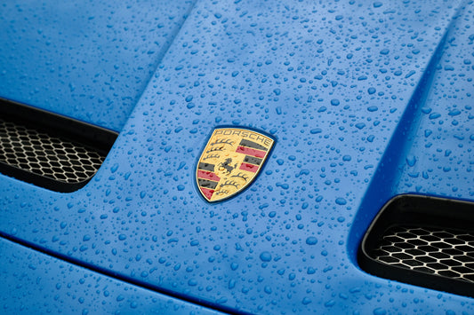 Natte blauwe motorkap vol waterdruppels na het wassen